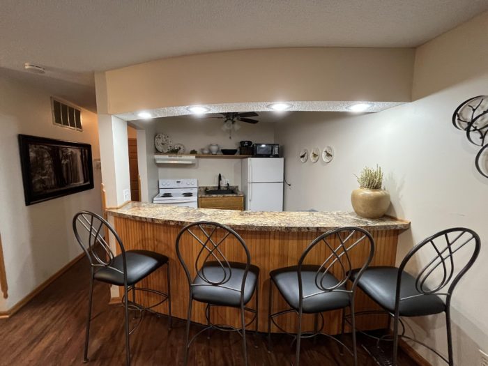 Kitchen with breakfast bar and seating at Cedar Ridge Apartments in Minnetonka, MN.